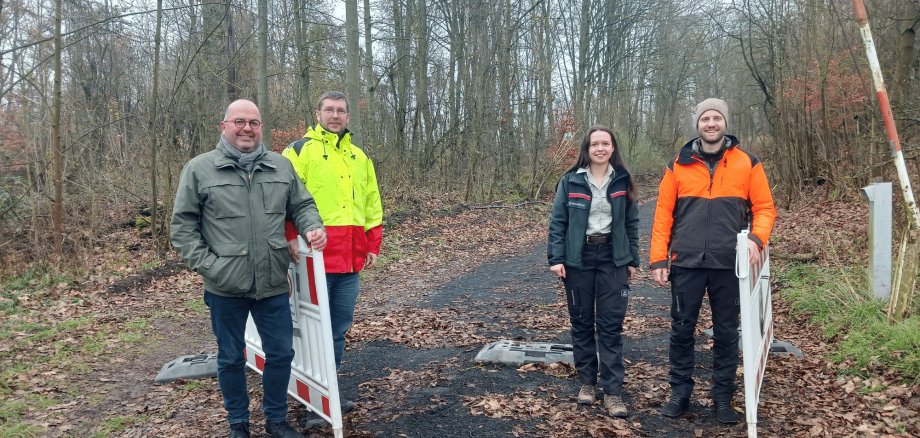 3 Männer und 1 Frau stehend im Wald