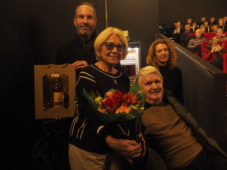 Frau mit Blumenstrauß und 3 weiteren Personen